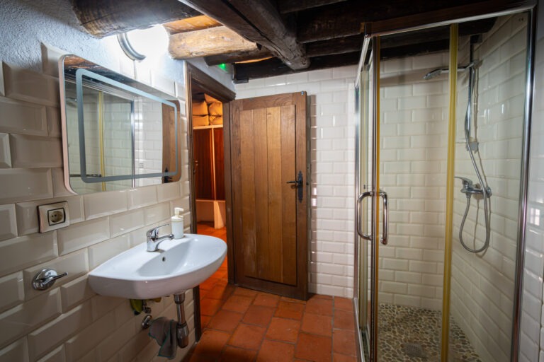 Lavabo con espejo LED en el baño privado de la habitación de 7 plazas en Albergue Rural San Blas