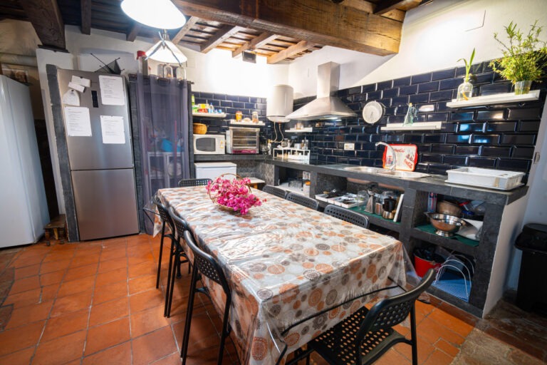 Cocina completa equipada con electrodomésticos y mesa de comedor para huéspedes en Albergue Rural San Blas